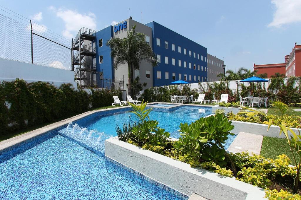 una piscina con fontana di fronte a un edificio di One Cuernavaca a Cuernavaca