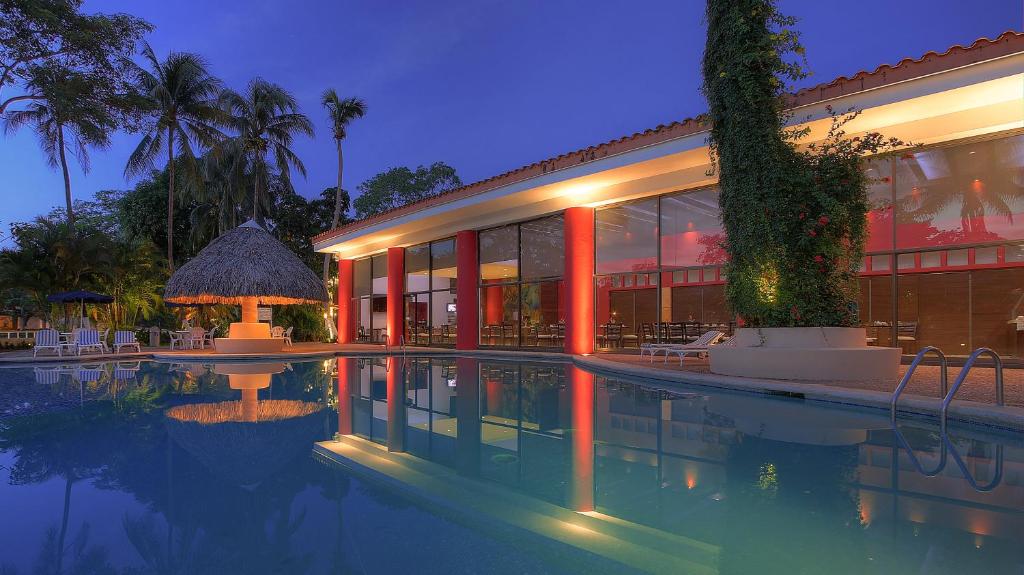 une maison avec une piscine la nuit dans l'établissement Fiesta Inn Villahermosa Cencali, à Villahermosa