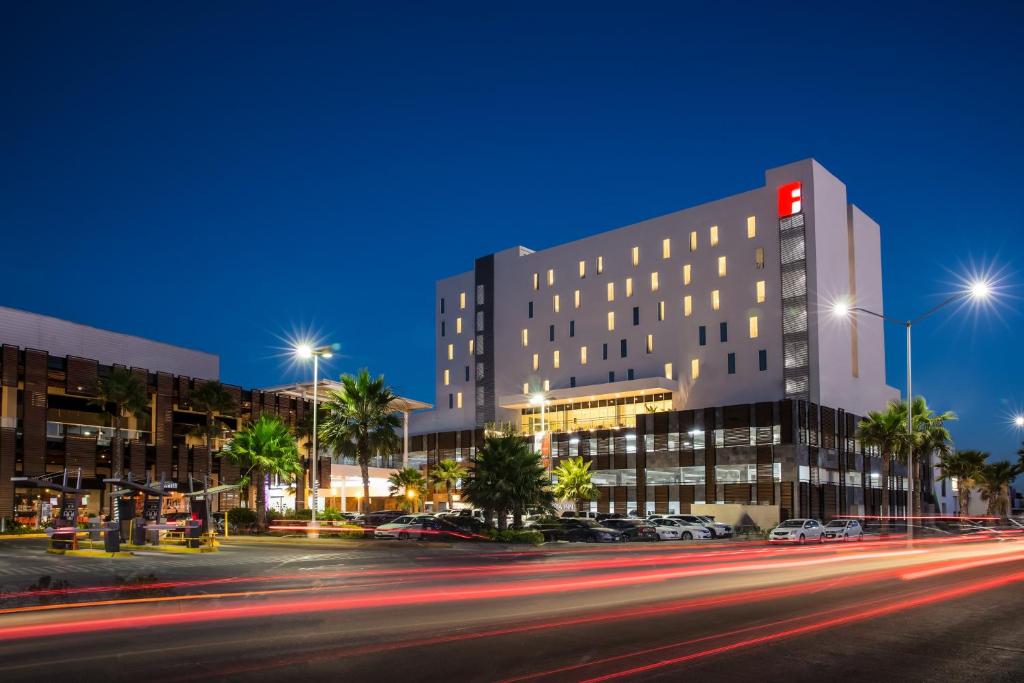 a building on a city street at night at Fiesta Inn Los Mochis in Los Mochis