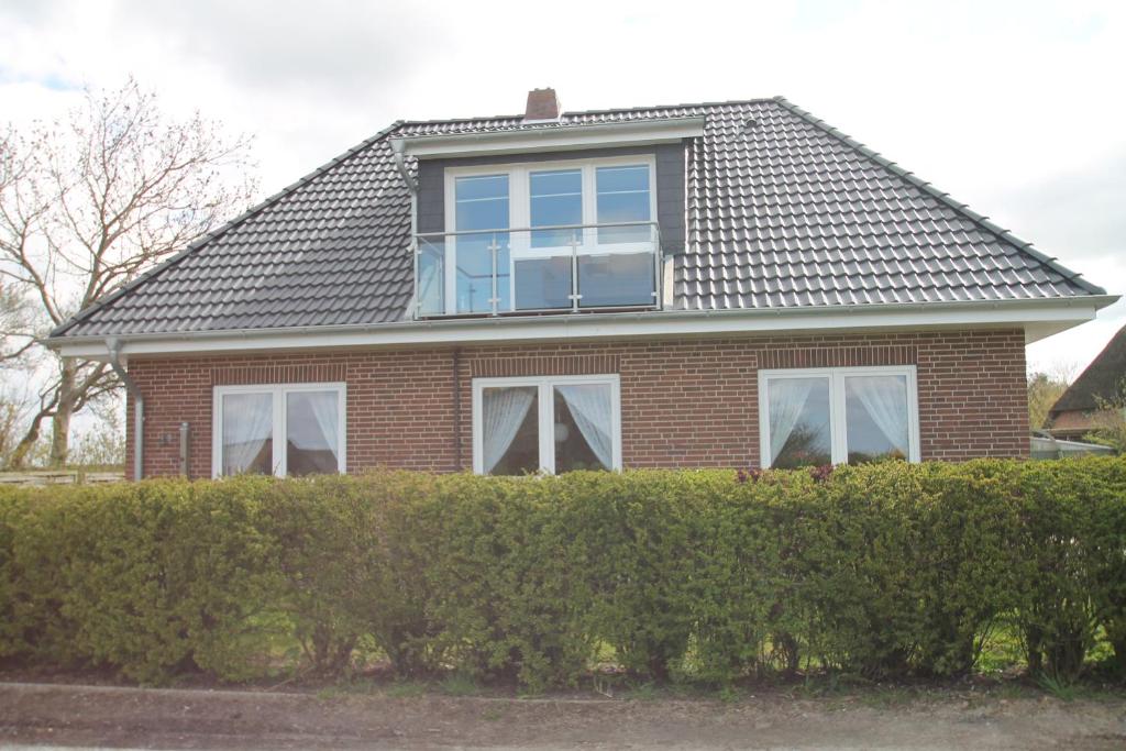 een huis met een raam op een heg bij Haus Dres Ferienwohnung 1 und 2 in Aventoft