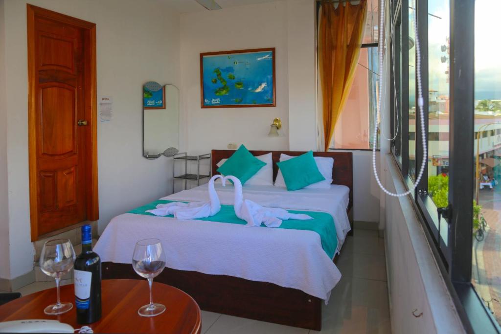 um quarto de hotel com dois cisnes numa cama em Hostal Sir Francis Drake em Puerto Ayora