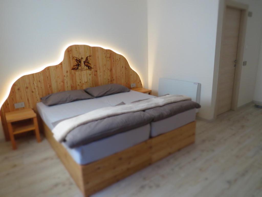 - une chambre avec un lit en bois et une tête de lit en bois dans l'établissement B&B A piè Paganella, à Terre d'Adige