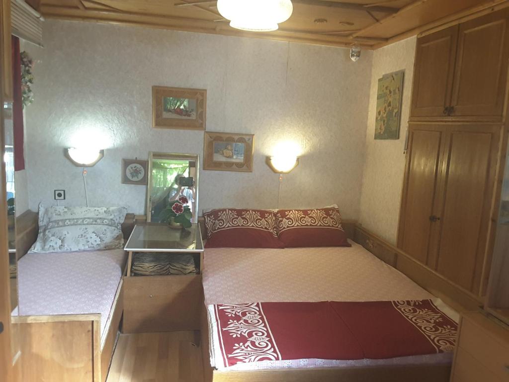 ヴェリコ・タルノヴォにあるDiana Guesthouseのベッドルーム1室(ベッド2台、壁に照明2つ付)