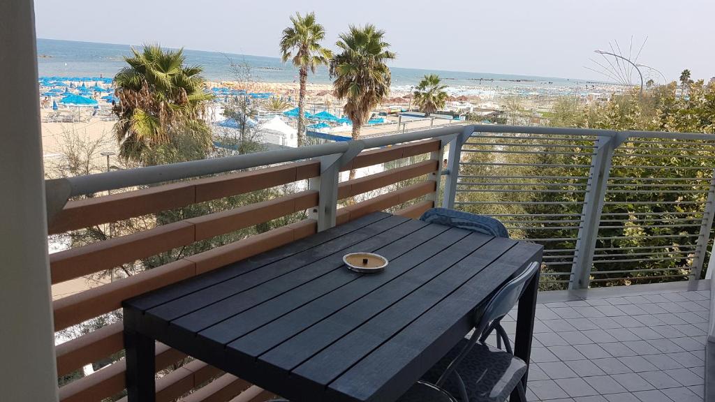 a wooden bench sitting on top of a balcony with the beach at Apartment Atlantic Roseto Beach in Roseto degli Abruzzi