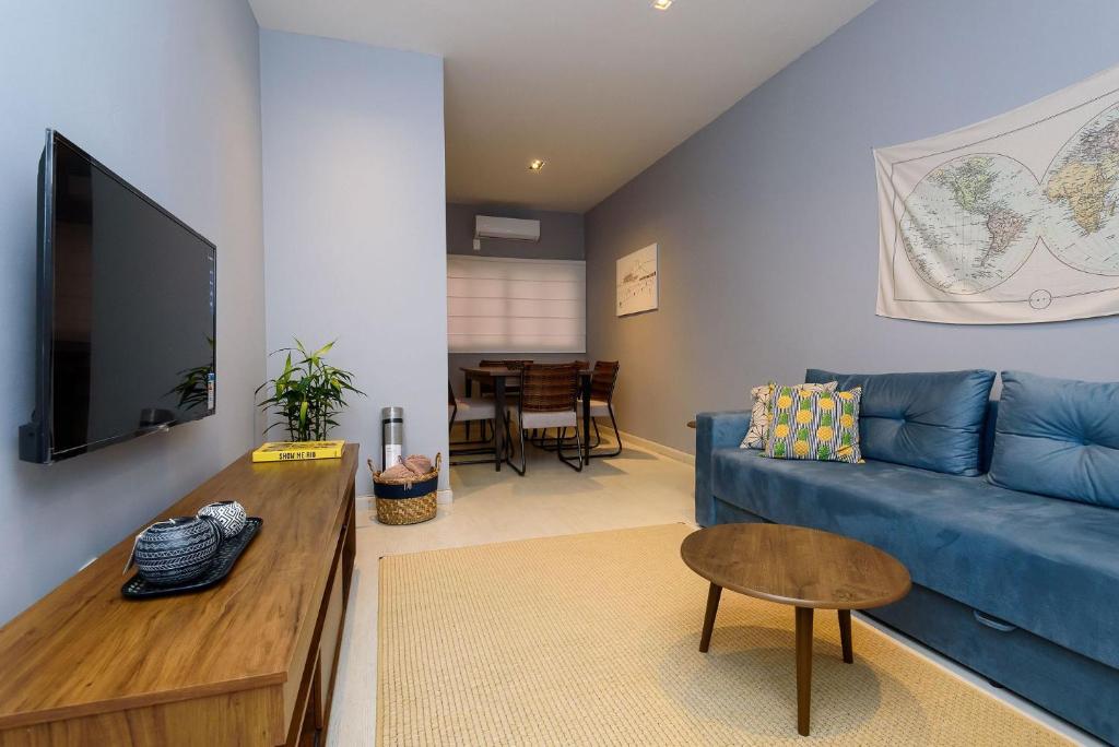 - un salon avec un canapé bleu et une table dans l'établissement Apartamento em Ipanema com garagem | BT 82/208, à Rio de Janeiro