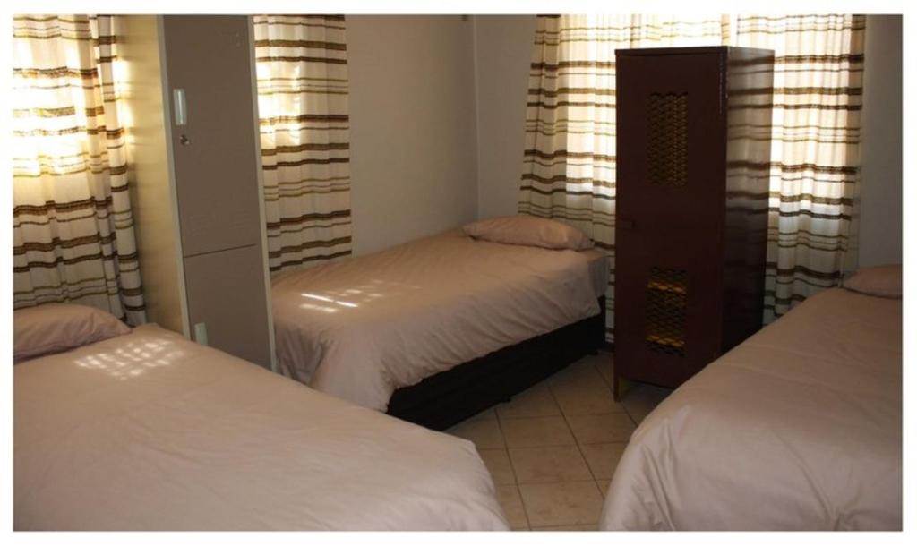 a bedroom with two beds and a mirror at Old farmhouse for 3 in Limpopo Province in Lephalale