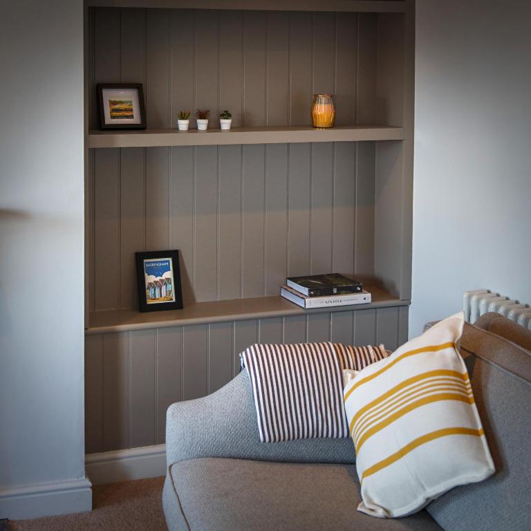 a living room with a couch and shelves at The Sands Sheringham in Sheringham