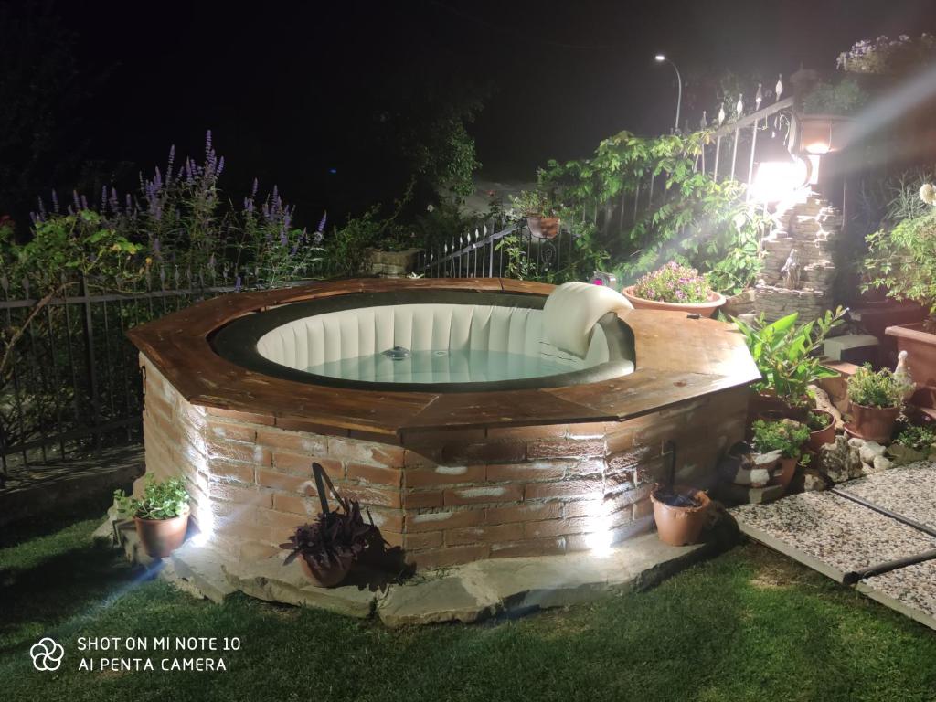 una bañera de hidromasaje en un jardín por la noche en BeB Villa Sorriso, en San Benedetto Val di Sambro
