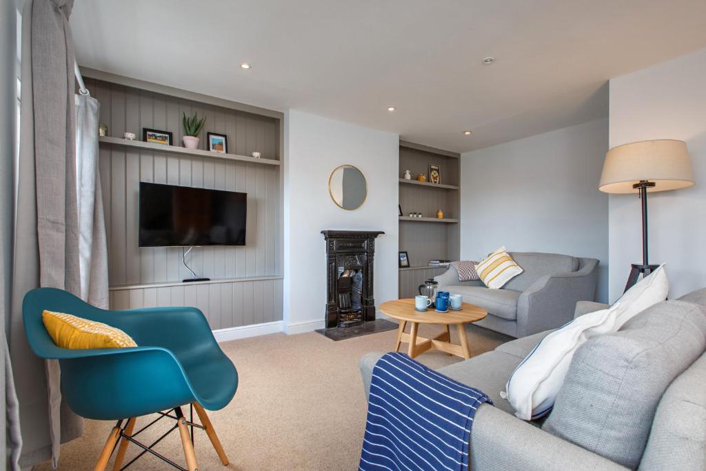 a living room with a couch and a tv at The Sands Sheringham in Sheringham