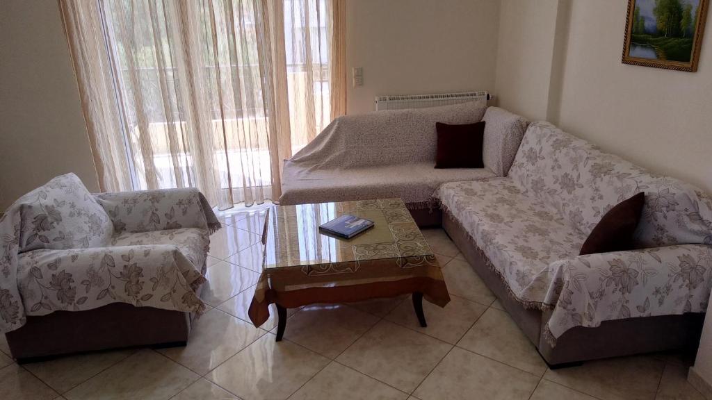 a living room with a couch and two chairs and a table at Classic-style apartment in Loutra Edipsou