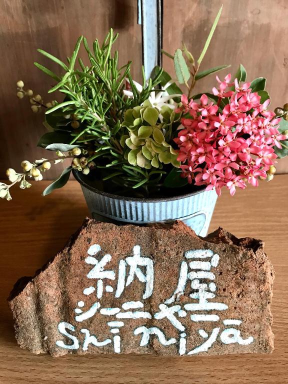 a vase filled with flowers sitting on top of a rock at Travelers House おーさんてぃん青空舎 in Taketomi