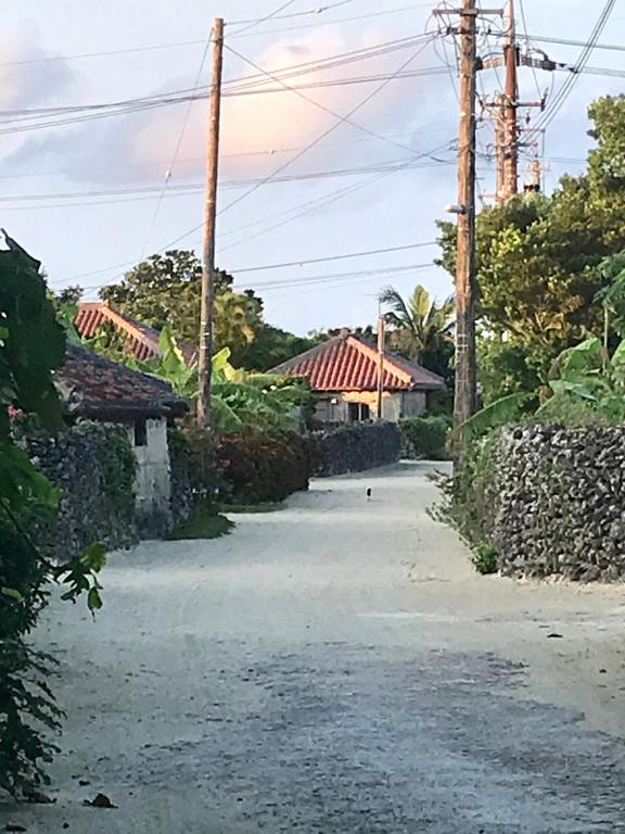 an empty road with a house in the background at Travelers House おーさんてぃん青空舎 in Taketomi