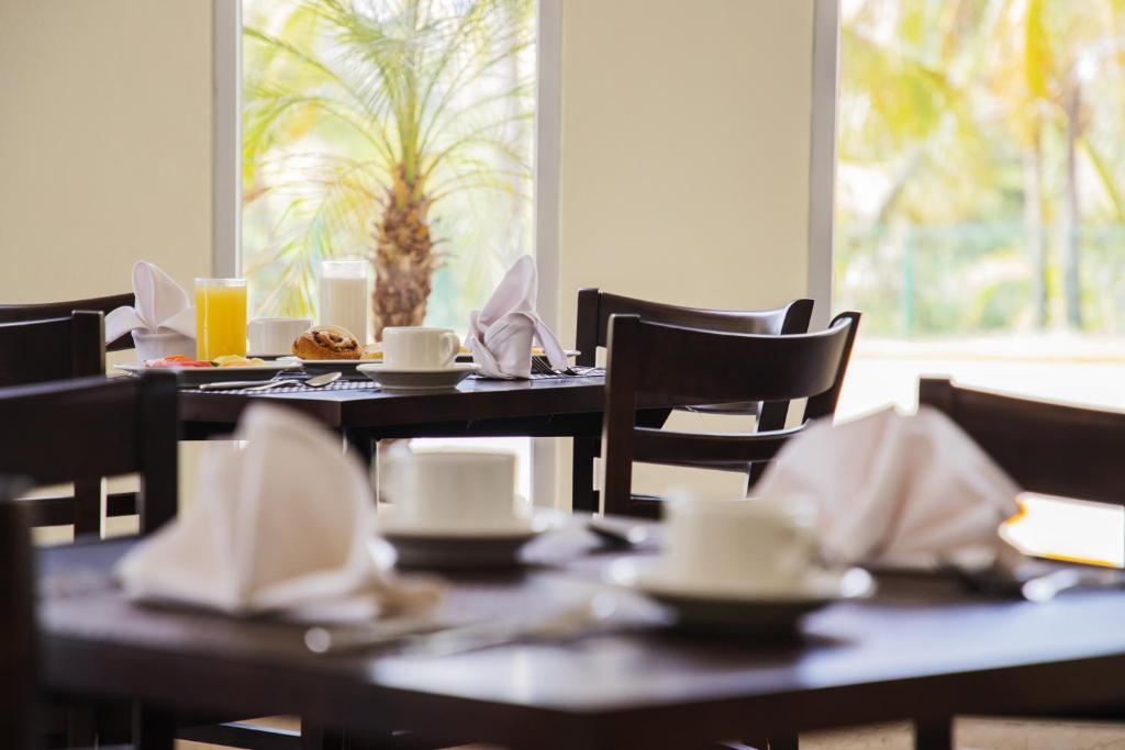 een eetkamer met tafels en stoelen met kopjes en servetten bij Gamma Tampico in Tampico
