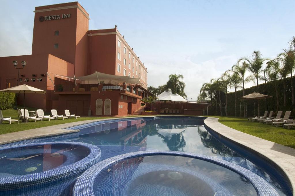 a swimming pool in front of a hotel at Fiesta Inn Cuernavaca in Cuernavaca