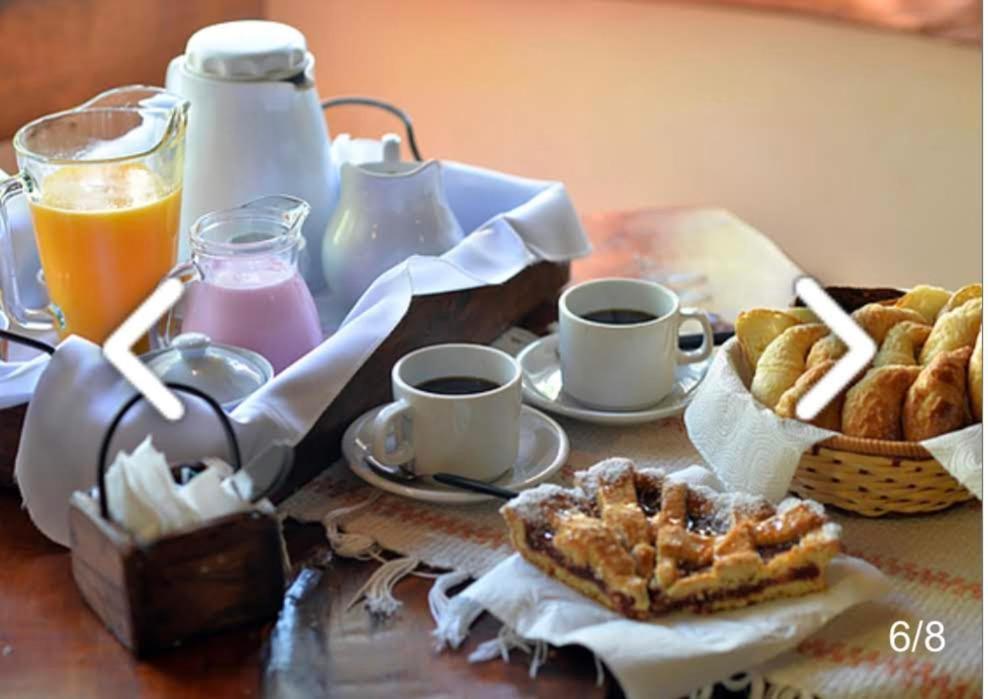 a table with a breakfast of coffee and pastries and orange juice at Cabañas del Bosque in Mar Azul