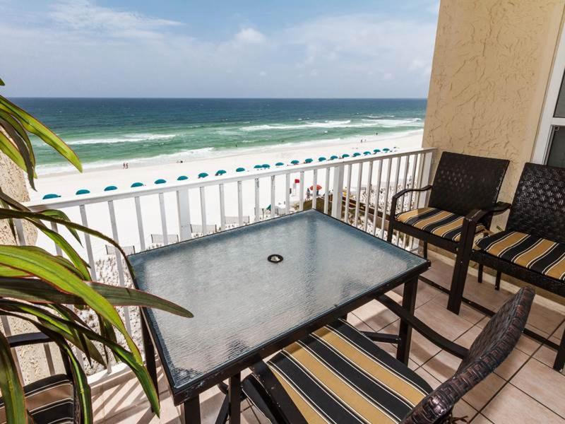 una mesa y sillas en un balcón con vistas a la playa en Island Echos 6th Floor Condos, en Fort Walton Beach