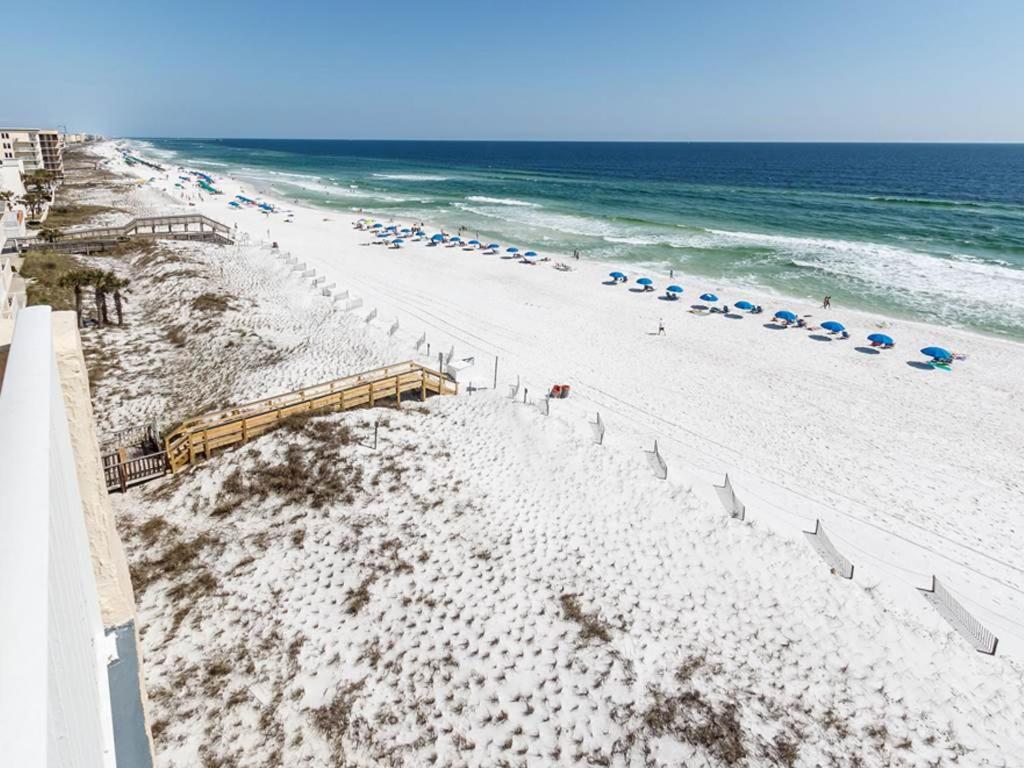 a beach with chairs and umbrellas and the ocean at Island Echos 7th Floor Condos in Fort Walton Beach