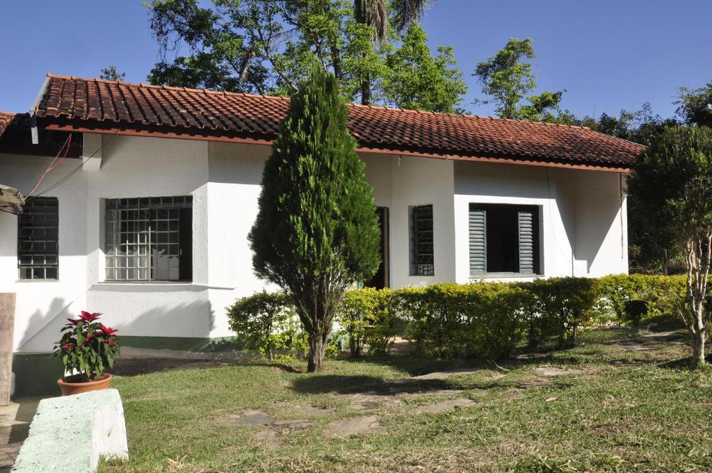 a white house with a red roof at Chalé e Camping Daragona 1 in Águas de Lindóia