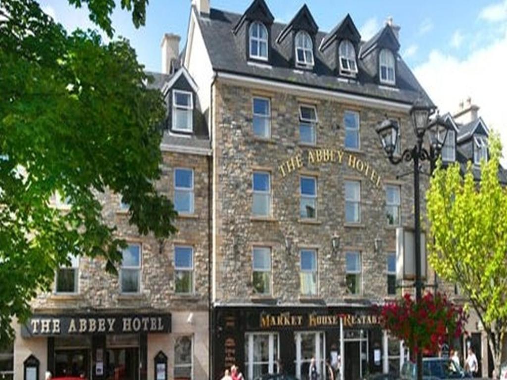 un gran edificio de ladrillo con un cartel. en Abbey Hotel Donegal, en Donegal