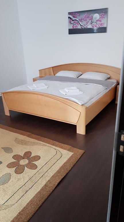 a wooden bed in a room with a rug at Apartament 13 Central in Târgu-Mureş