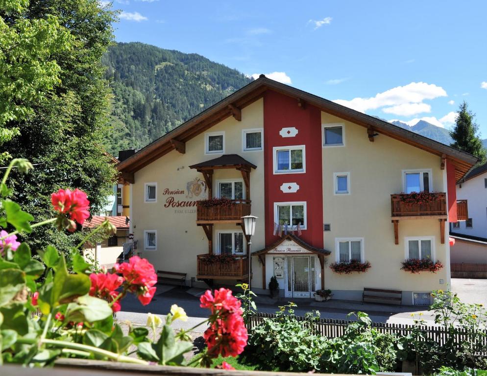 a large building with flowers in front of it at Pension Posauner in Dorfgastein