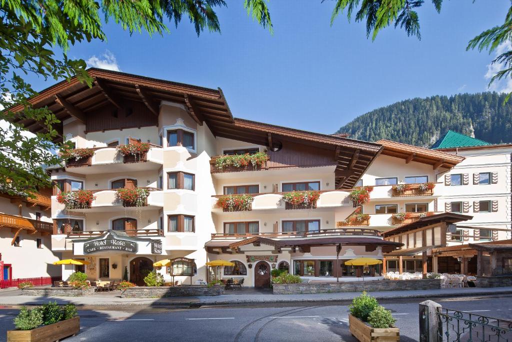 a large white building with flowers in front of it at Hotel Rose in Mayrhofen