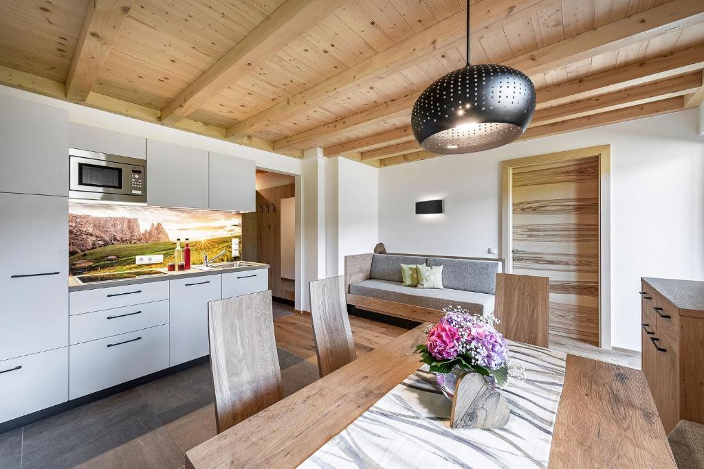 eine Küche und ein Esszimmer mit Holzdecke in der Unterkunft Foreserhof in Völs am Schlern