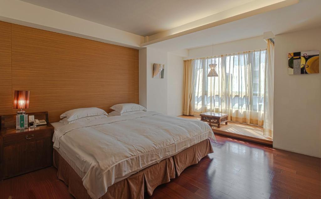a bedroom with a large bed and a large window at Einhan Resort in Yuchi