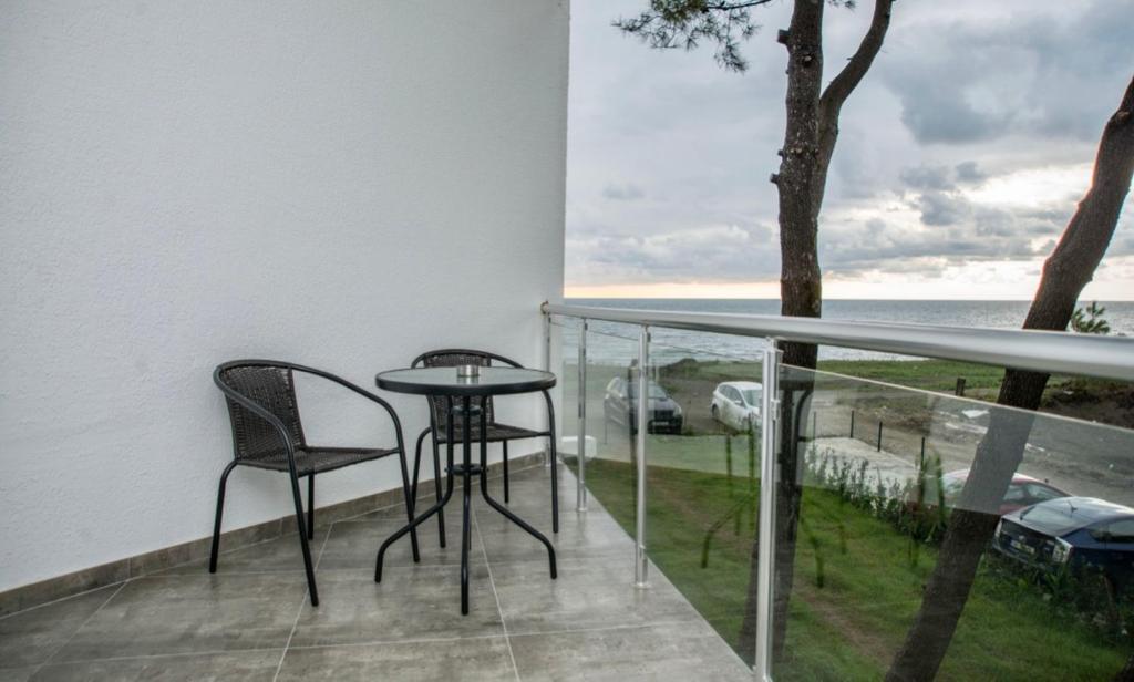 a balcony with a table and chairs and the ocean at Hotel Scala in Shekhvetili
