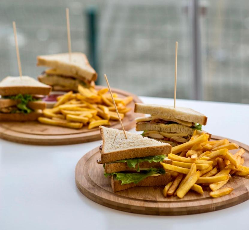 two plates of sandwiches and french fries on a table at Hotel Scala in Shekhvetili