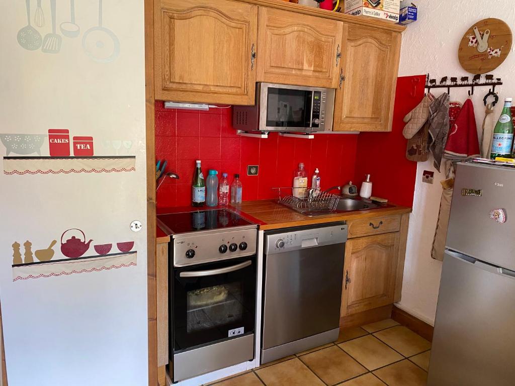 a small kitchen with a stove and a refrigerator at Sallanches 3101 Route de Nant Cruy immeuble le Grand R in Sallanches