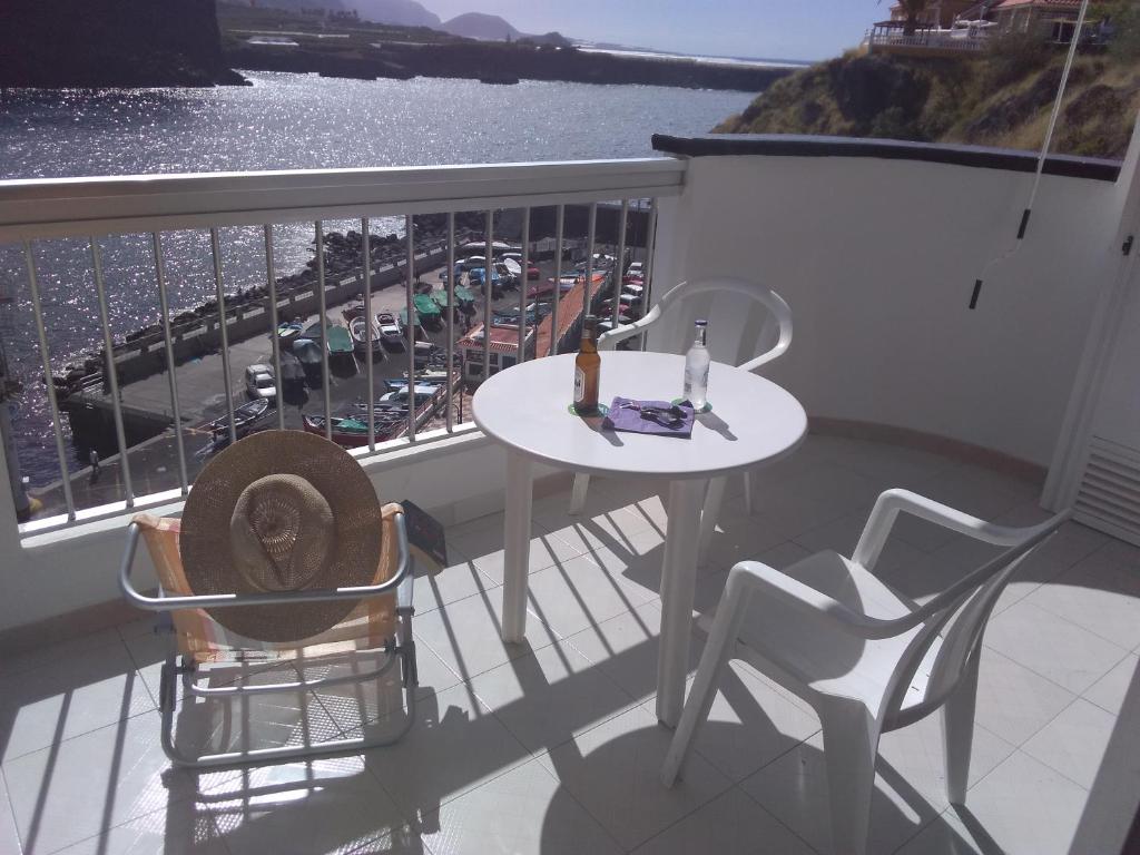 a balcony with a table and chairs and a view of a harbor at Preciosos atardeceres san marcos in Icod de los Vinos