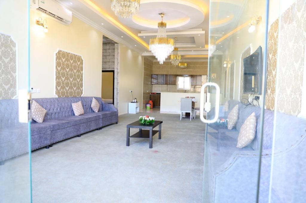 uma sala de estar com um sofá roxo e uma mesa em Al Chaffa Chalets em Turaif