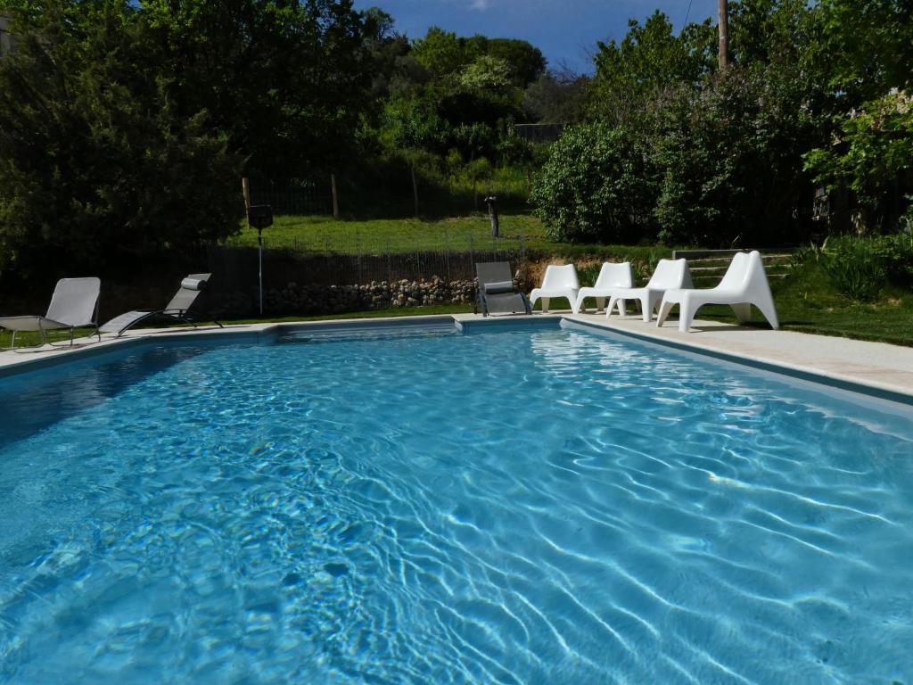 瓦朗索爾的住宿－L'auguste maison d'hôtes，院子里带白色椅子的游泳池