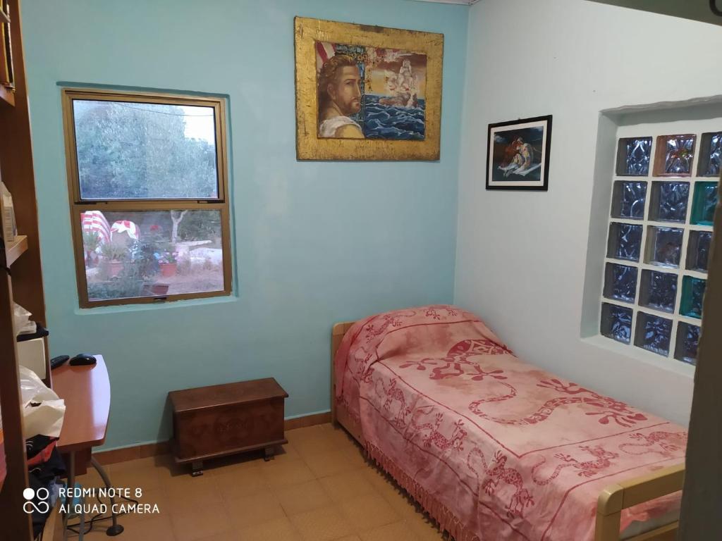 mała sypialnia z łóżkiem i oknem w obiekcie Casa Carlo w mieście Alghero