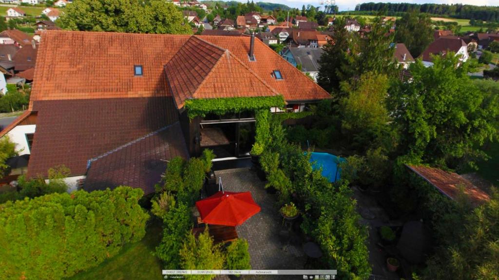 ein Haus mit einem roten Regenschirm davor in der Unterkunft Bijou Hotel / Love and Romance in Kallnach