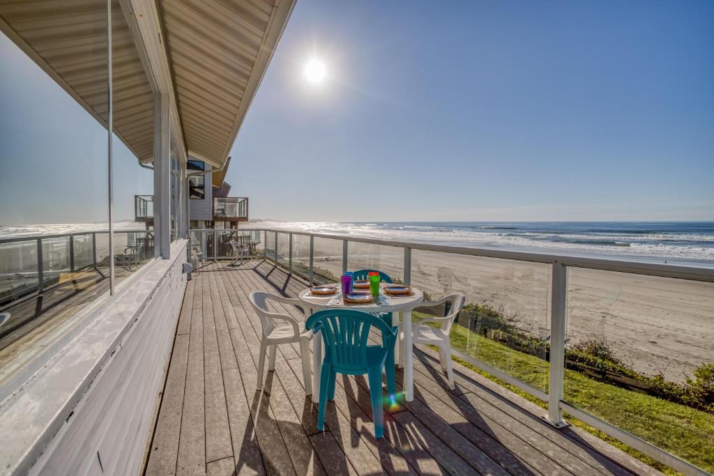 a table and chairs on a balcony overlooking the beach at Sea Lyons in Lincoln City