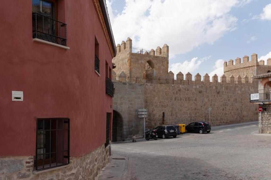 un grande muro di mattoni con un grande castello di Casas del Castillo, 2 ad Ávila