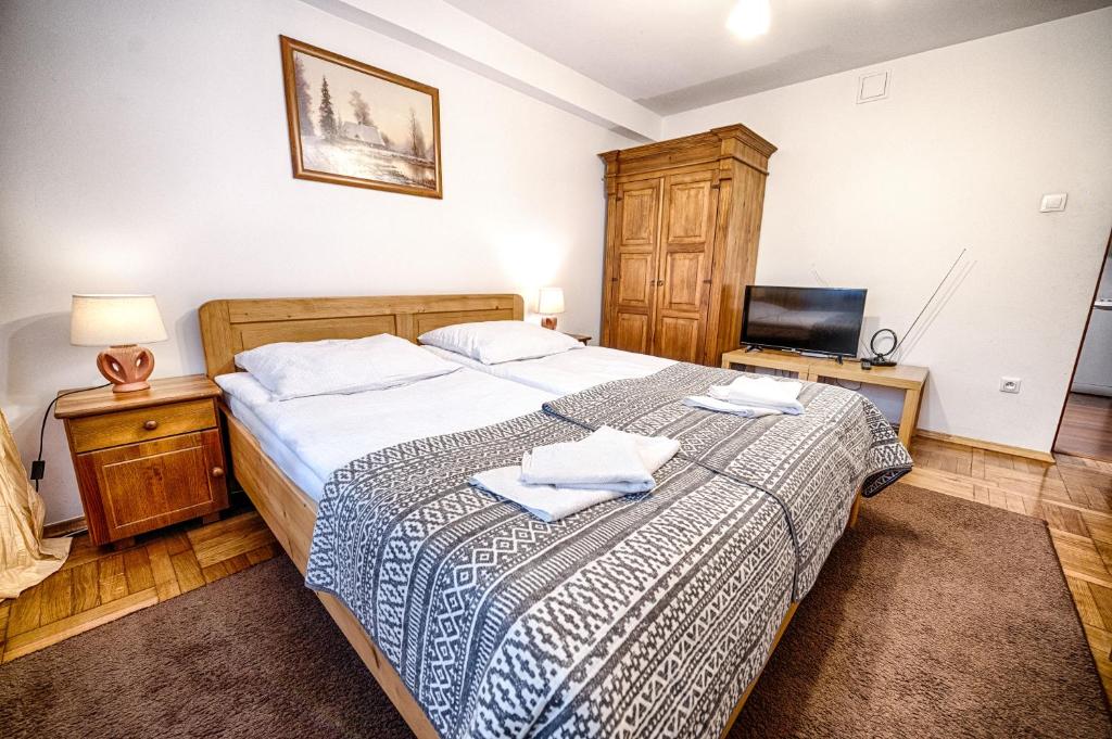 1 dormitorio con 1 cama con 2 toallas en Bagry Rooms, en Cracovia