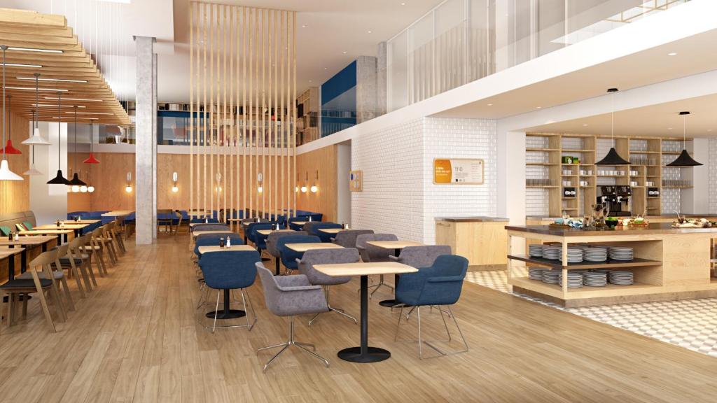 a restaurant with blue chairs and tables and a counter at Holiday Inn Express Amsterdam - North Riverside by IHG in Amsterdam