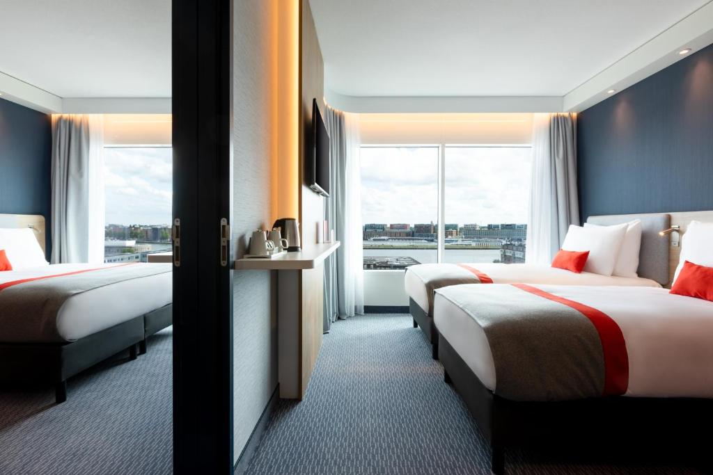 a hotel room with two beds and a window at Holiday Inn Express Amsterdam - North Riverside by IHG in Amsterdam
