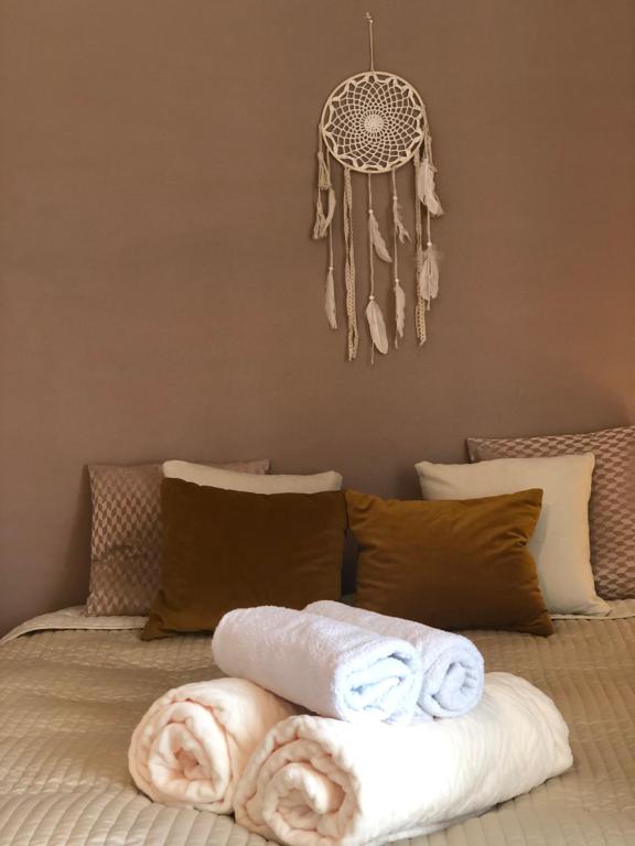 a bed with towels and a dream catcher on it at Apartament Łapacz Snów in Tylicz