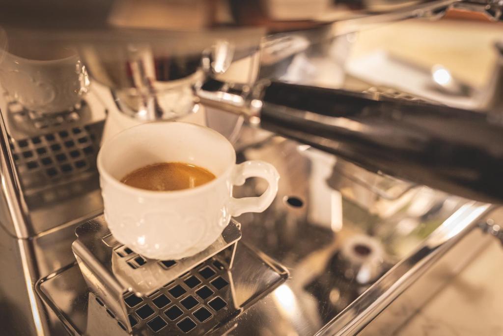 a cup of coffee sitting on top of a stove at Hotel Posta in Cecina