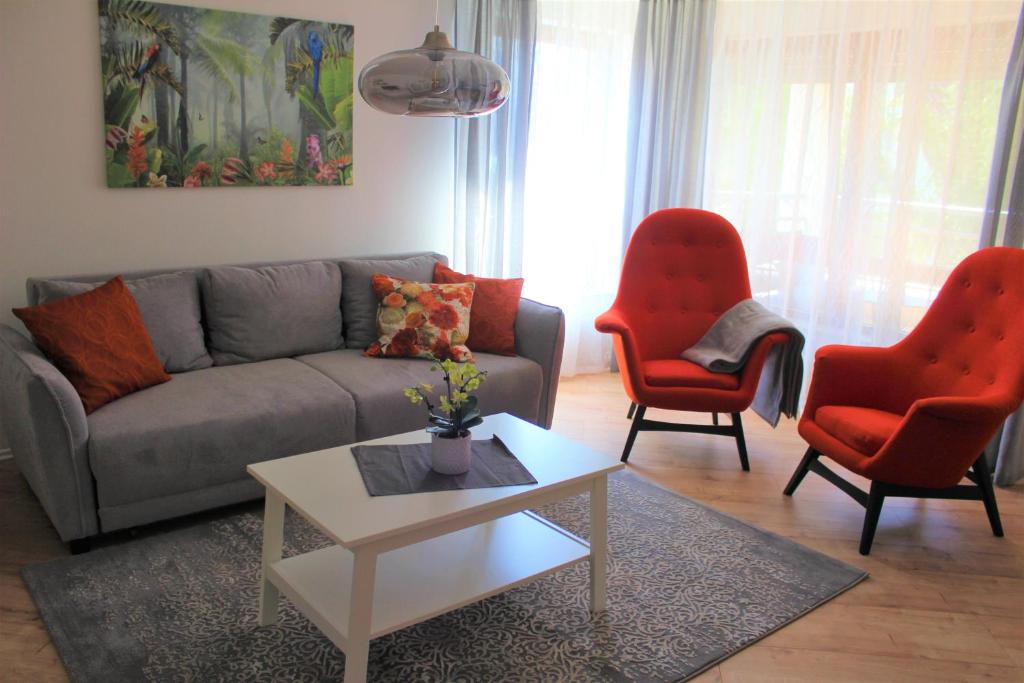 sala de estar con sofá y 2 sillas rojas en Apartment with parking garage, en Metzingen