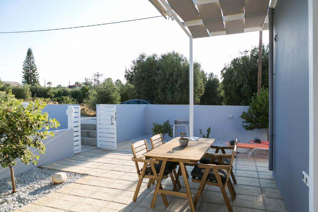 a patio with a wooden table and chairs at Manos Housing Units in Gouves