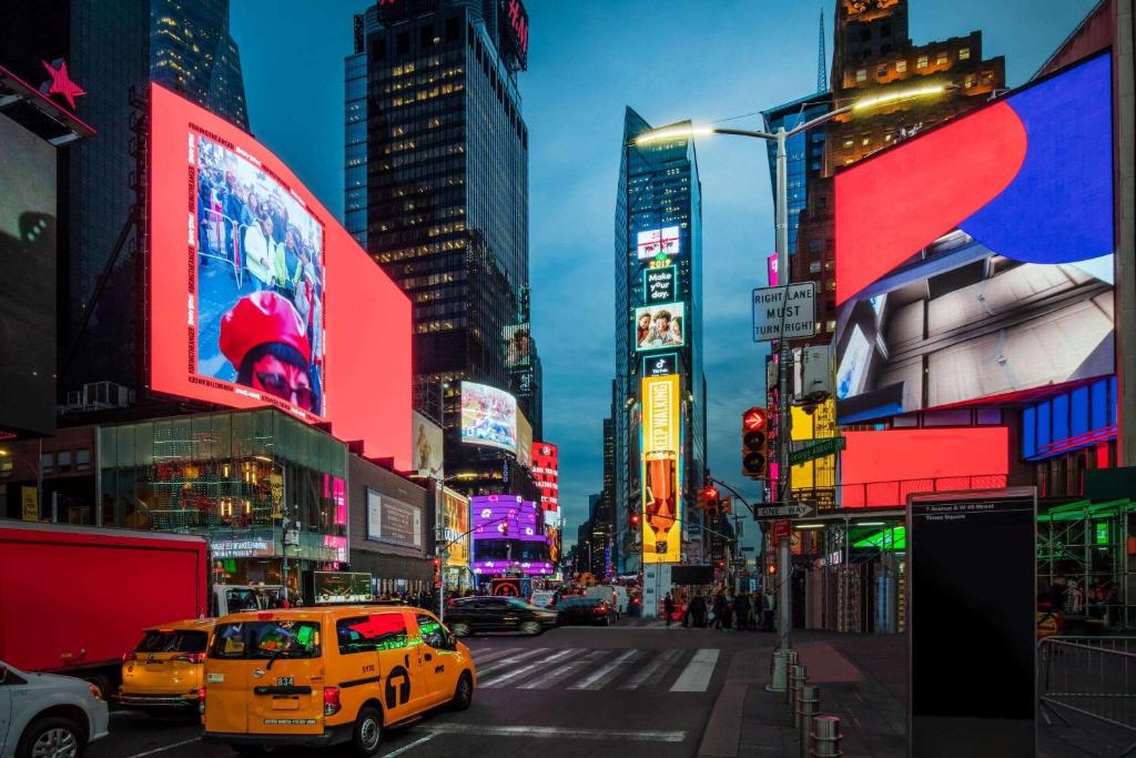 eine belebte Stadtstraße mit einem gelben Taxi in der Unterkunft La Quinta by Wyndham Time Square South in New York