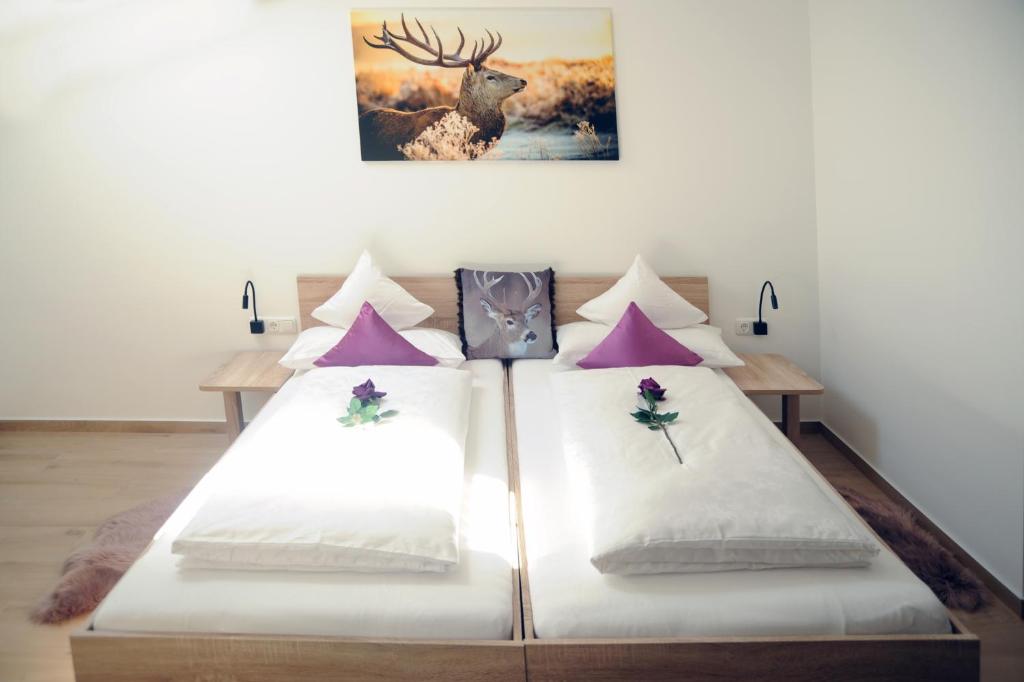 a bed room with two beds and a painting on the wall at Pension Lerchenfeld in Schongau