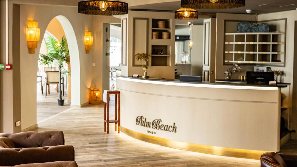 a hotel lobby with a reception counter and chairs at Palm Beach in Ajaccio