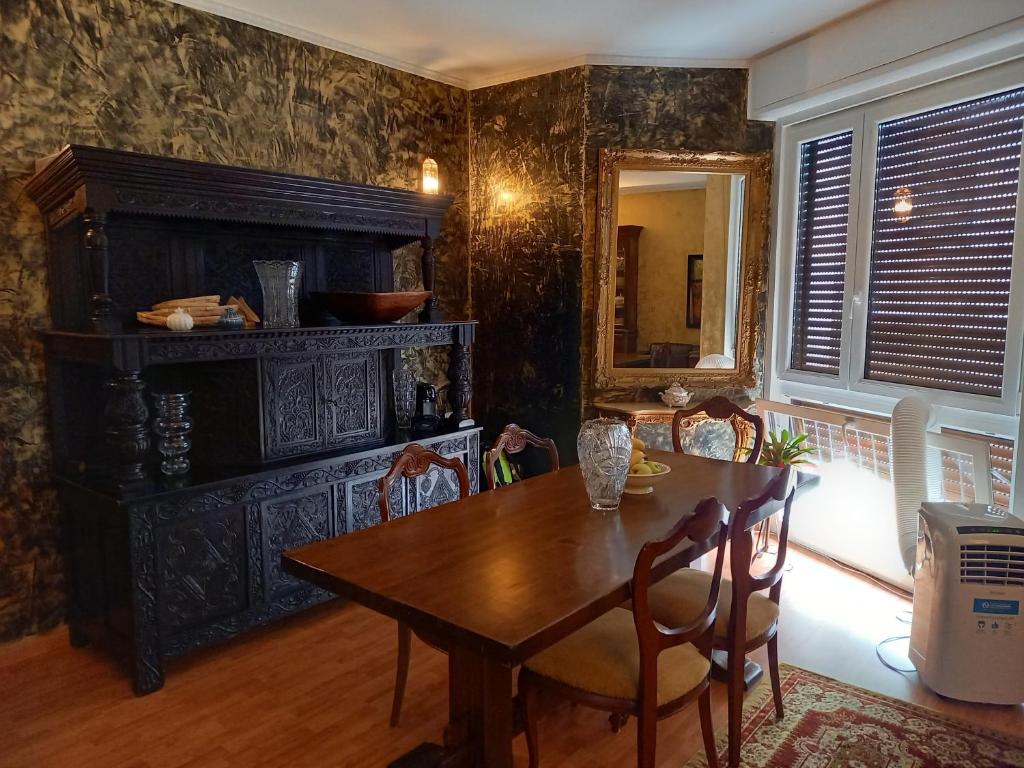 uma sala de jantar com uma mesa de madeira e cadeiras em B&B I FILOKSENIA em Trieste