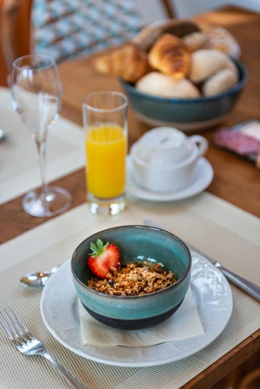 einen Tisch mit einer Schüssel Müsli und einer Schale Obst in der Unterkunft Boutique hotel Shamon in Eeklo